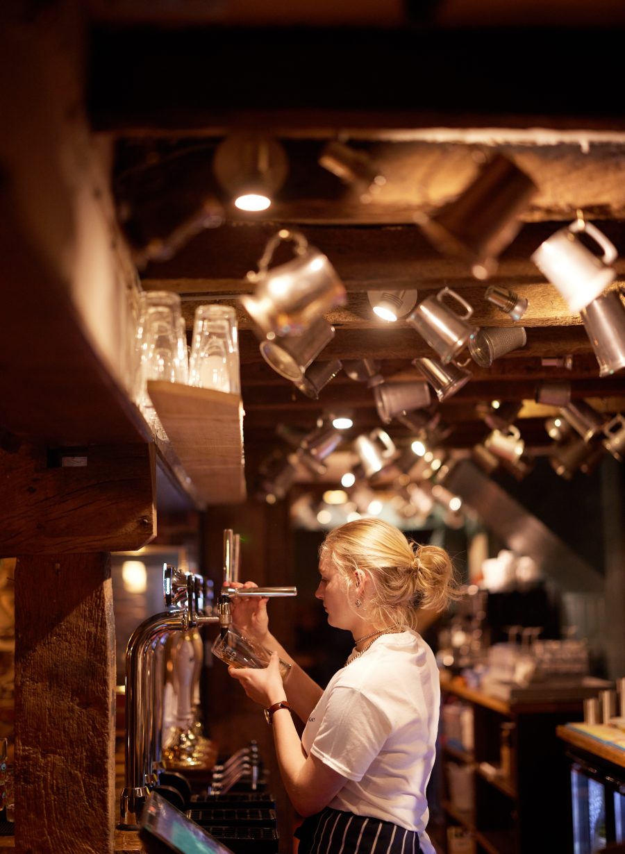 friendly bar staff portrait behind counter